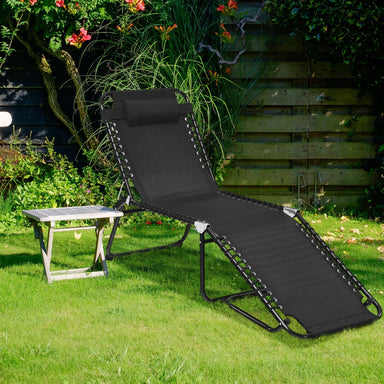 Adjustable Folding Beach Lounge Chair with Pillow set up in a scenic garden. The chair is comfortably positioned on the grass, demonstrating its outdoor usability.