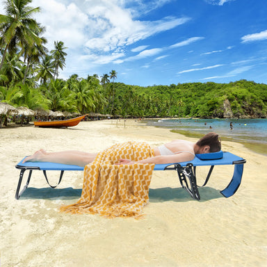 Adjustable Beach Chaise Lounge Chair with Face Hole by Dream Yard Oasis, being used on a sandy beach, showcasing its comfort with a person lounging under the sun.