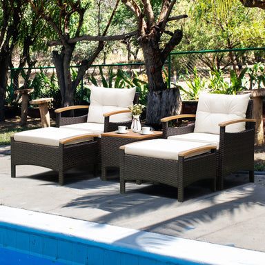 5-Piece Patio Conversation Set with Cushions, Coffee Table & 2 Multi-Purpose Ottomans, showcasing two armchairs and a coffee table by a pool surrounded by lush greenery.