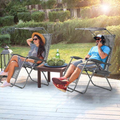 People relaxing in Dream Yard Oasis Folding Recliner Lounge Chairs with Canopy, enjoying the outdoor setting with a cup holder and adjustable features.