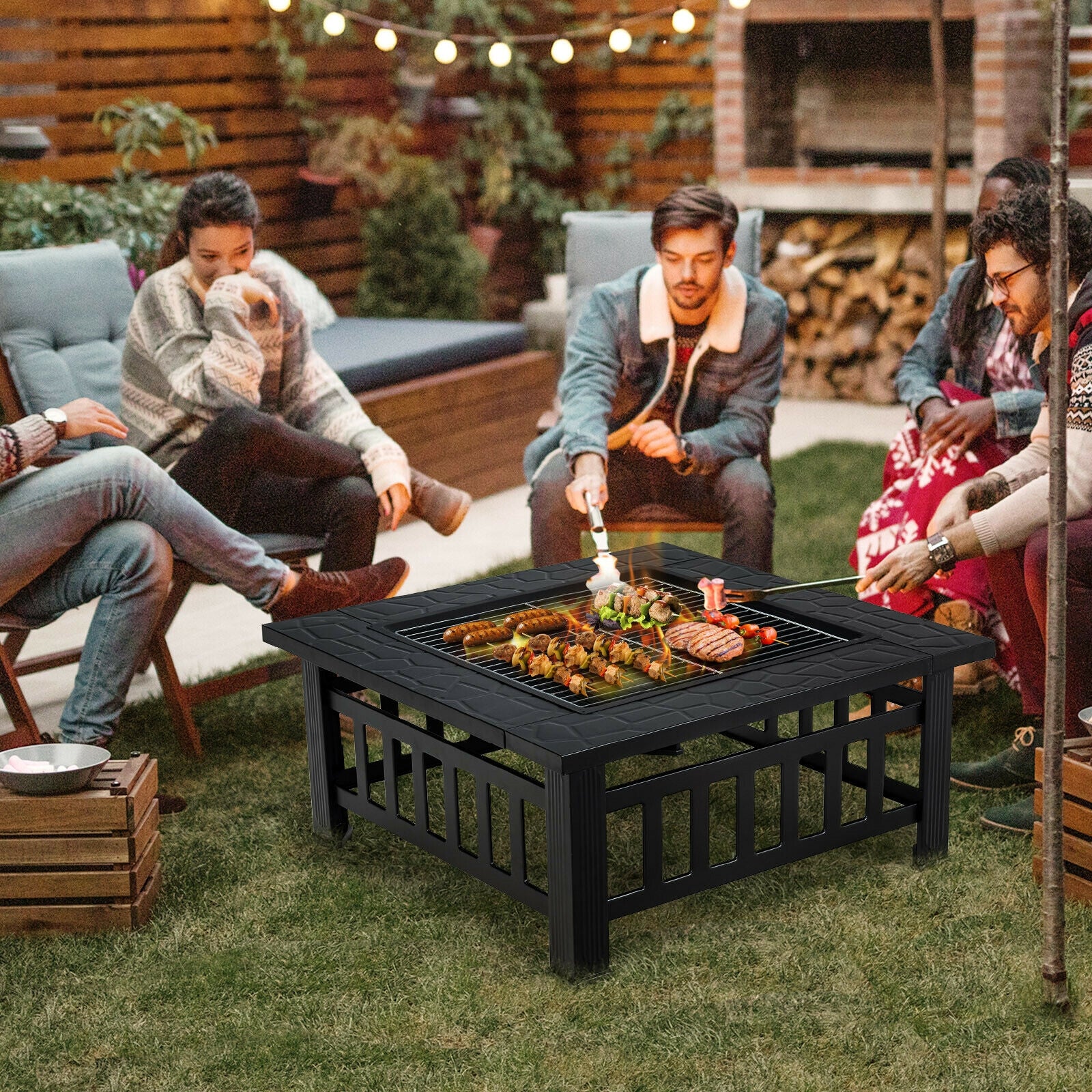32-Inch 3-In-1 Outdoor Square Fire Pit Table with BBQ Grill, Ice Bucket & Rain Cover being used by friends enjoying BBQ grilling and roasting marshmallows around a warm fire in a backyard setting.