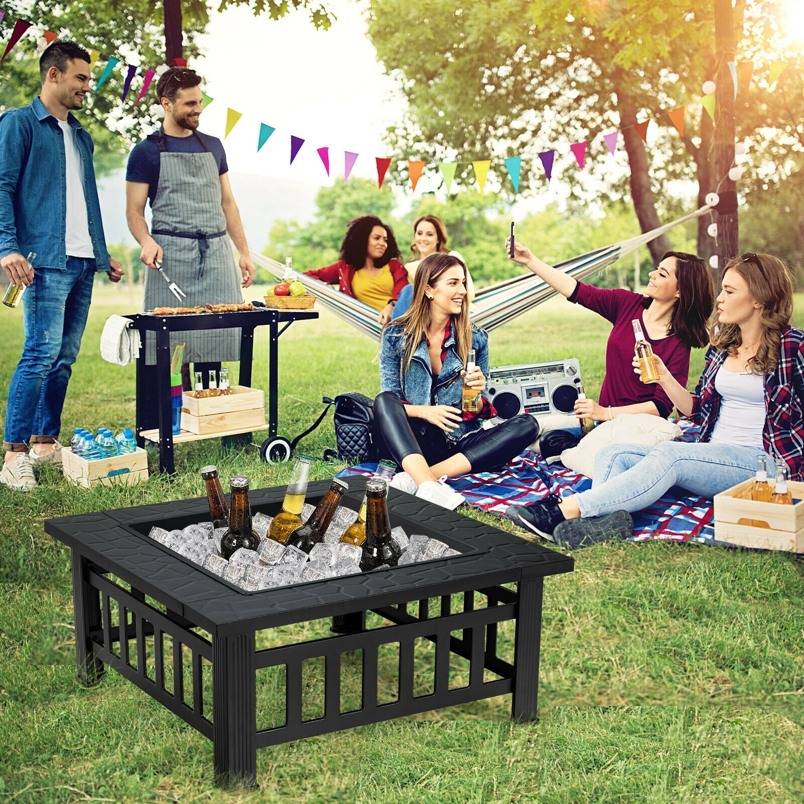 Social gathering around the 32-Inch 3-In-1 Outdoor Square Fire Pit Table with BBQ Grill, Ice Bucket & Rain Cover, enjoying drinks and barbecue in a lively outdoor setting.