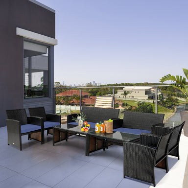 4-Piece Navy Cushioned Rattan Patio Furniture Set with Coffee Table displayed on a stylish balcony, showcasing modern design and comfortable seating for both indoor and outdoor use.