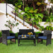 4-Piece Navy Cushioned Rattan Patio Furniture Set arranged in a lush outdoor setting, perfect for entertaining and relaxation.
