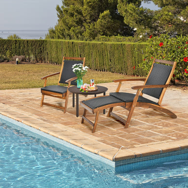 Relaxing outdoor scene featuring the Patio Rattan Folding Lounge Chair with Acacia Wood Frame & Retractable Footrest by Dream Yard Oasis, accompanied by a small table and surrounded by greenery and a serene poolside.