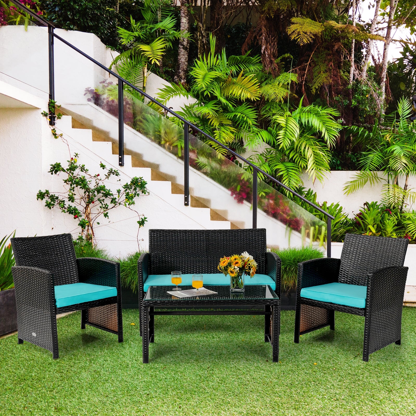4-Piece Cushioned Patio Rattan Furniture Set in Green arranged in an outdoor setting surrounded by lush greenery, perfect for relaxation.