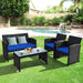 4-Piece Navy Rattan Patio Furniture Set with Weather-Resistant Cushions & Tempered Glass Table in a backyard setting, featuring two armchairs and a loveseat with blue cushions.