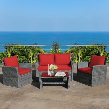 4-Piece Patio Rattan Furniture Set by Dream Yard Oasis featuring cozy red cushions, perfect for outdoor gatherings with a stunning ocean view in the background.