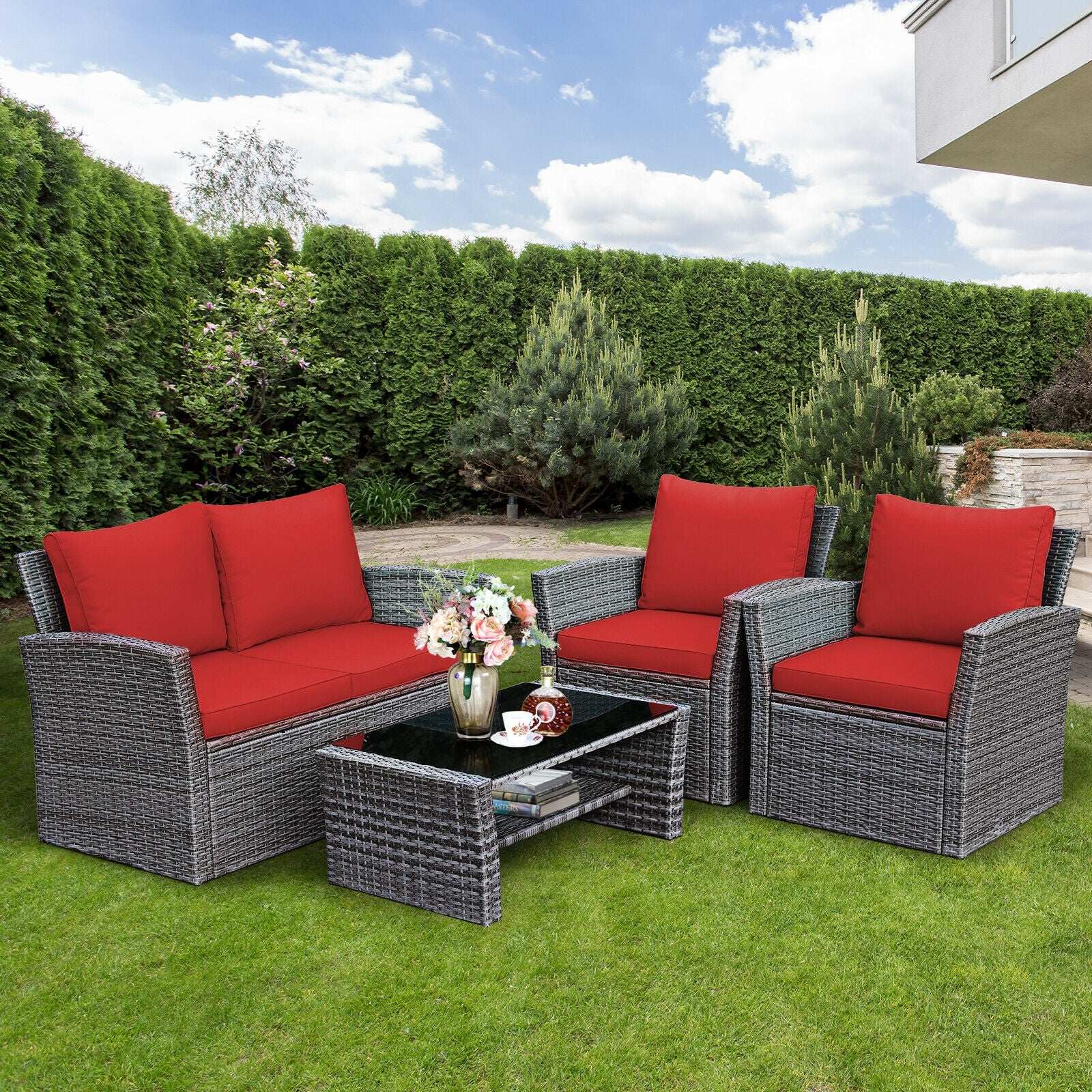 4-Piece Patio Rattan Furniture Set with Cushions, Table & Storage Shelf - Red displayed in a beautiful garden setting, showcasing its elegance and comfort for outdoor gatherings.