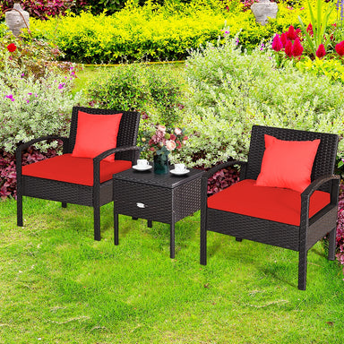 3 Piece PE Rattan Wicker Sofa Set featuring two comfy chairs with red cushions and a stylish coffee table, set in a vibrant outdoor garden.