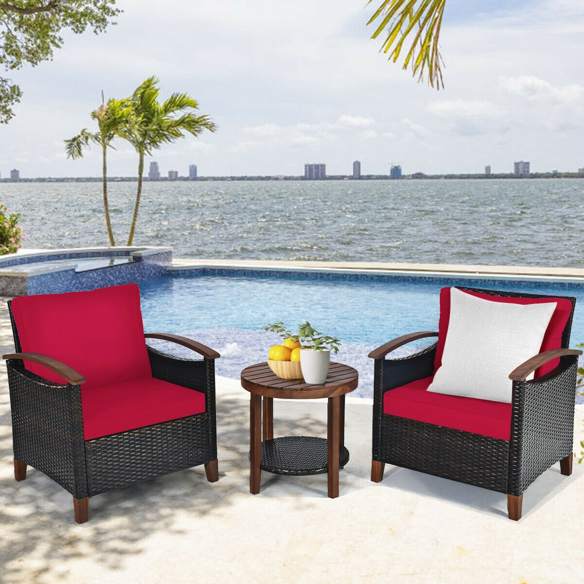 The 3 Piece Solid Wood Frame Patio Rattan Furniture Set with Red Cushions set by a pool, perfect for outdoor relaxation.