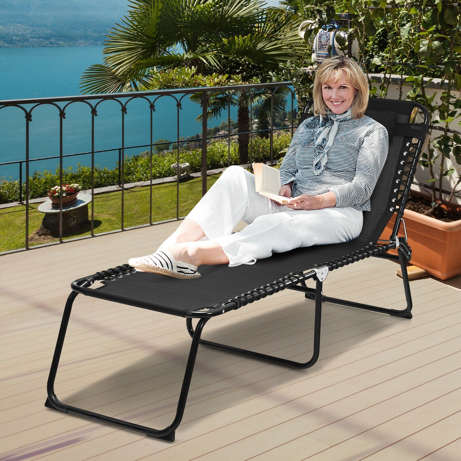 Adjustable Folding Beach Lounge Chair with Pillow, designed for relaxation on a patio with stunning views, perfect for reading or sunbathing.