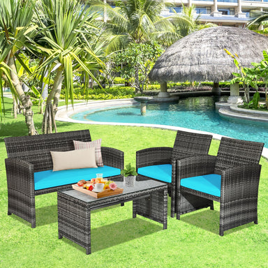 4-Piece Turquoise Rattan Patio Furniture Set with Cushions arranged in a tropical garden with a pool, showcasing a loveseat, two chairs, and a stylish coffee table.