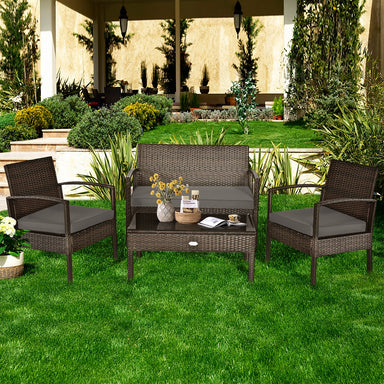 4-Piece Patio Rattan Furniture Set with Cushions, Loveseat, & Table - Brown Outdoor Bliss displayed in a lush garden setting, featuring comfortable seating and elegant design.