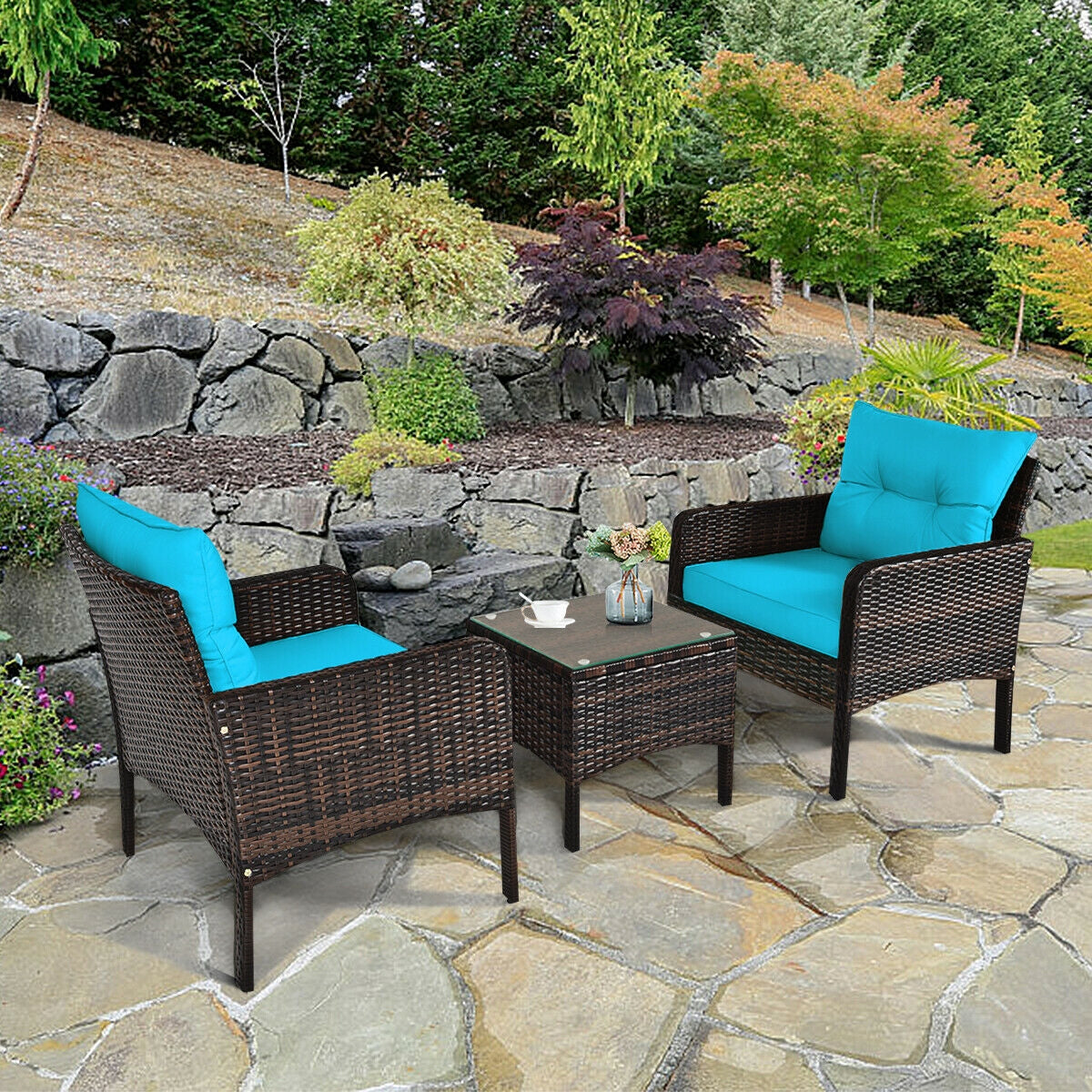 3-Piece Turquoise Outdoor Rattan Conversation Set with Cushions displayed outdoors, featuring two stylish chairs and a coffee table surrounded by greenery.