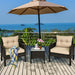 Stylish setup of the 3-Piece Beige Rattan Outdoor Patio Conversation Set with cushions, table, and an umbrella overlooking a scenic view.