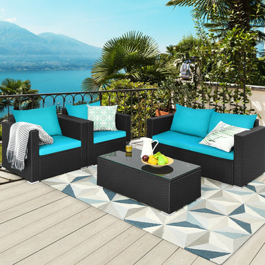 4-Piece Turquoise Patio Rattan Sofa Set with Cushions & Tempered Glass Table showcased on a beautiful balcony overlooking a scenic view.