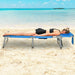 Person enjoying the 5-Position Adjustable Folding Beach Lounge Chair with Removable Pillow - Blue, lying face down on the beach, showcasing the chair's comfortable design for ultimate relaxation.