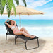 Woman relaxing on a Multi-Purpose Foldable Recline Lounge Chair with 4-Position Backrest & 2-Position Footrest by the beach, enjoying the sun and sea.