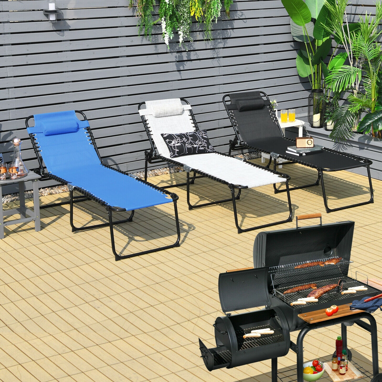 Multi-Purpose Foldable Recline Lounge Chair with 4-Position Backrest & 2-Position Footrest - Black, displayed in a garden setting with multiple lounge chairs and a grill.