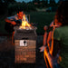 Enjoy a cozy gathering around the 40,000 BTU Outdoor Propane Fire Bowl Column. Friends relaxing by the smokeless fire pit, featuring a brown stacked stone finish.