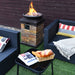 40,000 BTU Outdoor Propane Fire Bowl Column surrounded by outdoor seating, featuring flames, and a cozy ambiance for gatherings.