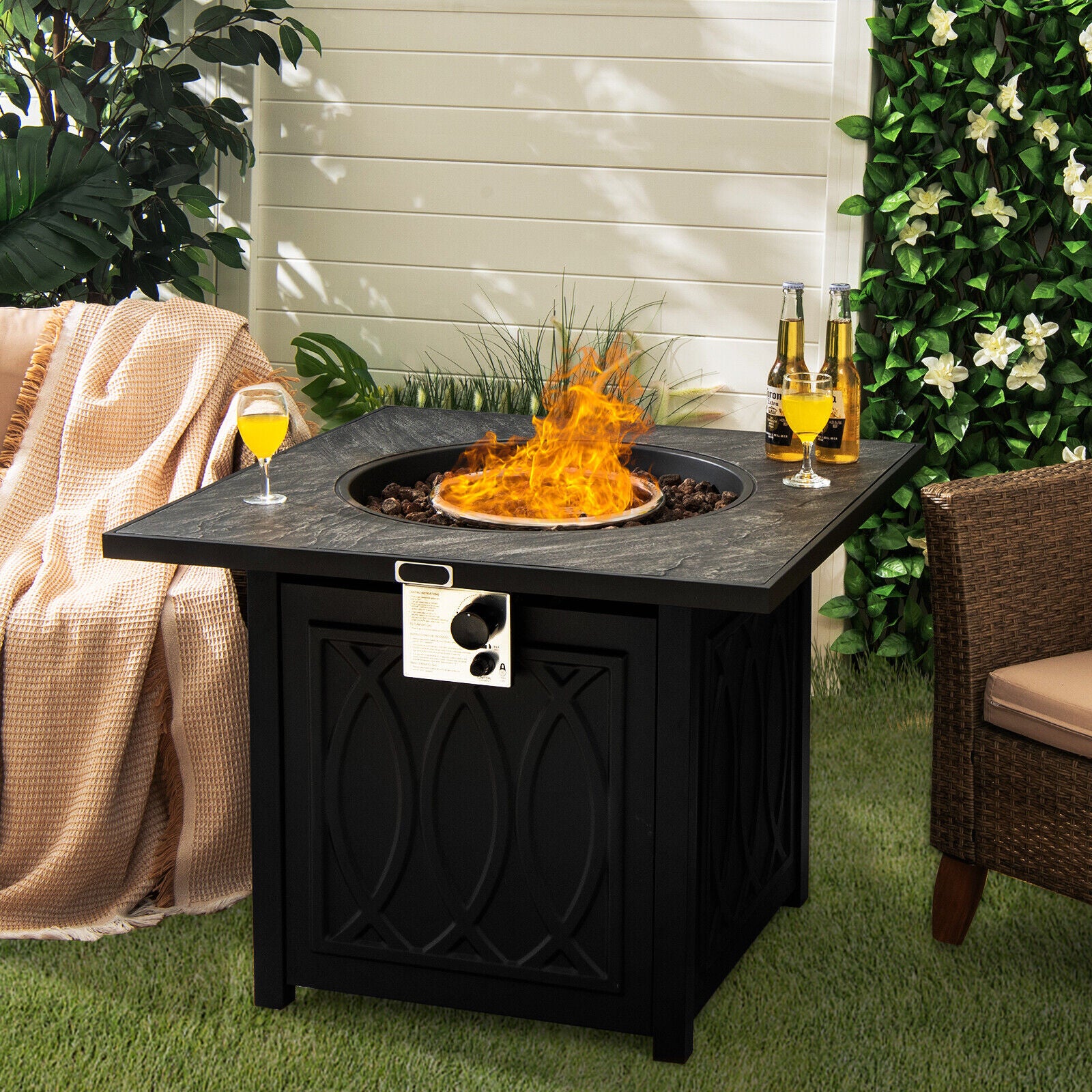 Beautiful outdoor setting featuring the 32-Inch Propane Fire Pit Table with Lava Rocks in use, flames glowing amidst drinks and cozy decor.
