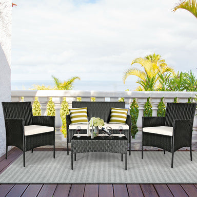 4-Pc Outdoor Patio Rattan Sofa Set with Cushions displayed on a sunny balcony, featuring black wicker chairs, a glass table, and stylish striped cushions. Perfect for outdoor relaxation.