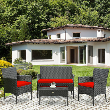 4 Piece Red Patio Rattan Sofa Set with Cushions & Glass Table displayed in a backyard setting, featuring weather-resistant materials ideal for outdoor relaxation.