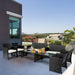 4-Piece Weather-Resistant Rattan Patio Seating Set with Cushions & Glass Coffee Table displayed on a modern balcony, featuring stylish black rattan chairs and a coffee table with a glass surface.