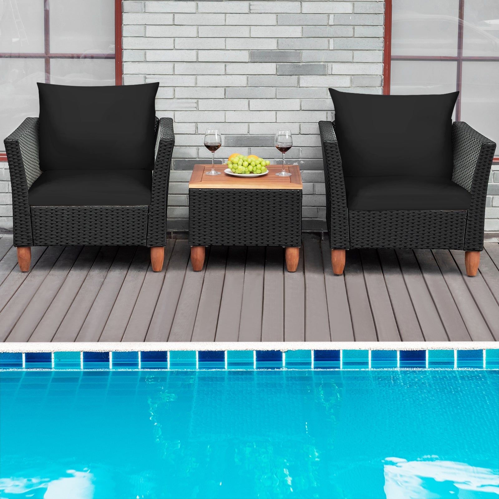 3-Piece Black Rattan Patio Furniture Set with Plush Cushions & Rustic Wood Coffee Table, designed for poolside relaxation with two black chairs and a table, surrounded by a swimming pool.