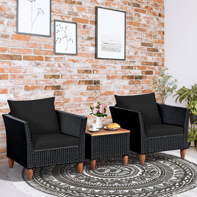 3-Piece Black Rattan Patio Furniture Set with Plush Cushions & Rustic Wood Coffee Table, featuring two stylish black chairs and a coffee table, set against a brick wall.