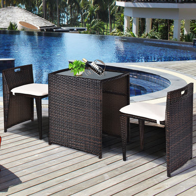 3-Piece Outdoor Wicker Patio Set with Cushions, No Assembly, Space-Saving Glass Table next to a pool, featuring two sleek chairs and a stylish table.