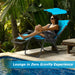 Folding Recliner Lounge Chair With Adjustable Shade Canopy & Cup Holder - Durable Steel Frame - Blue. A woman lounging on a blue recliner chair by a pool surrounded by lush greenery.