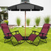 2-Piece Wine Zero Gravity Folding Lounge Chairs under a black umbrella in a backyard setting, ideal for enjoying the outdoors.