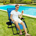 A young man relaxing in an oversized heavy duty lounge chair with adjustable backrest and cup holder by Dream Yard Oasis™, enjoying a drink by the pool in summer.