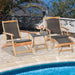 Outdoor view of the 2 Pieces Patio Rattan Folding Lounge Chair with Acacia Wood Table by the pool, showcasing a relaxing atmosphere with flowers and snacks on the table.