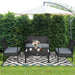 4-Piece Black Patio Rattan Furniture Set with Loveseat, Coffee Table & Cushions in a garden setting under an umbrella featuring a cozy arrangement with floral decor.