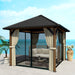 Outsunny 10' x 10' Waterproof Hardtop Metal Gazebo set up on a patio with soft furnishings and curtains, perfect for outdoor gatherings.