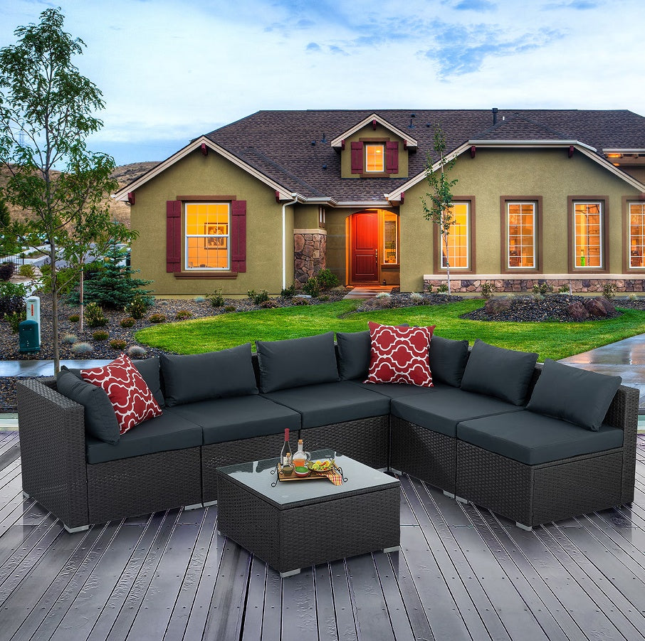 7-Piece Patio Furniture Set with Tempered Glass Coffee Table featuring dark gray PE wicker and comfortable cushions, ideal for outdoor gatherings, set in a beautiful garden setting.