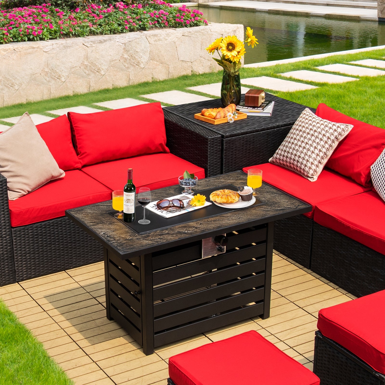 42-Inch Propane Fire Pit Table set on a patio, highlighted by red cushions and refreshments, illustrating its dual purpose as a chic coffee table with a 50,000 BTU heat output.