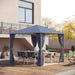 View of the Outsunny 10'x10' Hardtop Gazebo set up in a backyard, featuring a spacious dining area with a table and chairs under the elegant canopy.